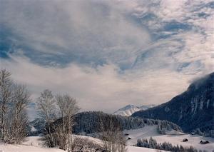 Snow covered landscape under wispy cloud cover