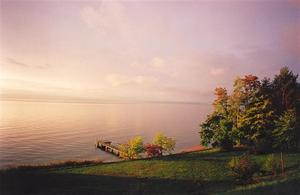 View from garden of pastel sunrise, pier and western colourful woods