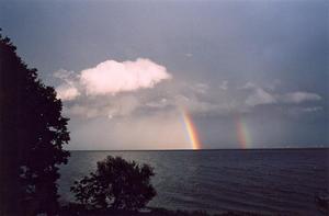 Grey lake scape with with cloud and rainbow
