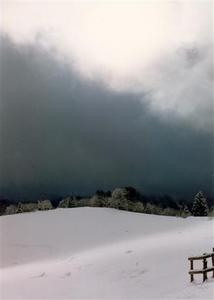 Grey and white snow covered hill and cloud