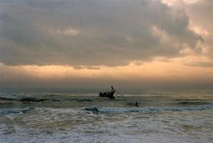 Fishermen rowing towards beach in the evening