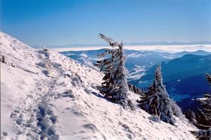 Snow on mountain slope overlooking blue valley