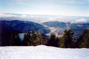 View of plains and small hills below snow covered hill