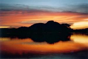 Red and blue sunset, with hill and reflection