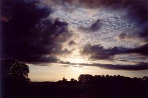 thin dark clouds in front of pale ambre sky