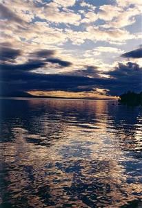 Bright clouds and dark clouds and their reflection as sun sets